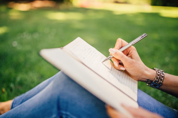 a writer writing on a green lawn