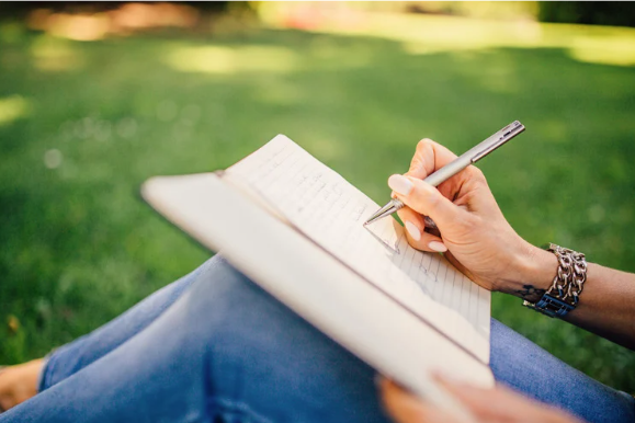 a writer writing on a green lawn